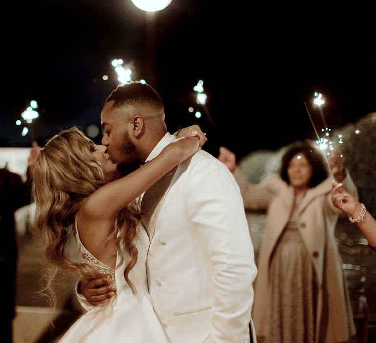 Bride and groom kissing during the confetti moment captured by Paul and Nanda 