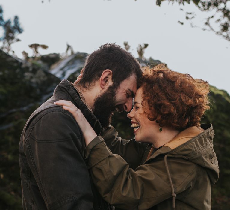 Couple place each others hands upon shoulders during engagement session