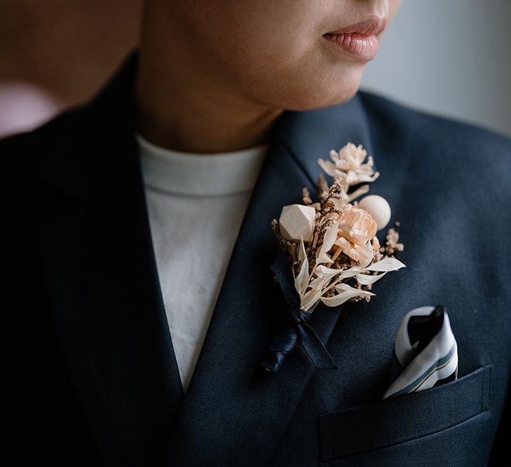 Asian bride in a navy wedding suit with neutral buttonhole