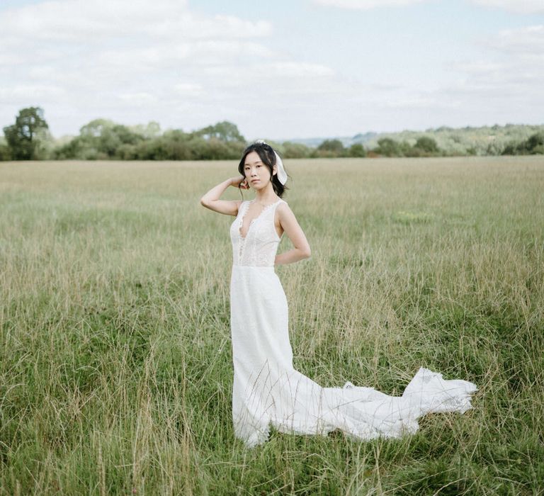 Bride in the fields of Berwick Lodge wearing plunge neck boho wedding dress with floral bodice and tulle skirt