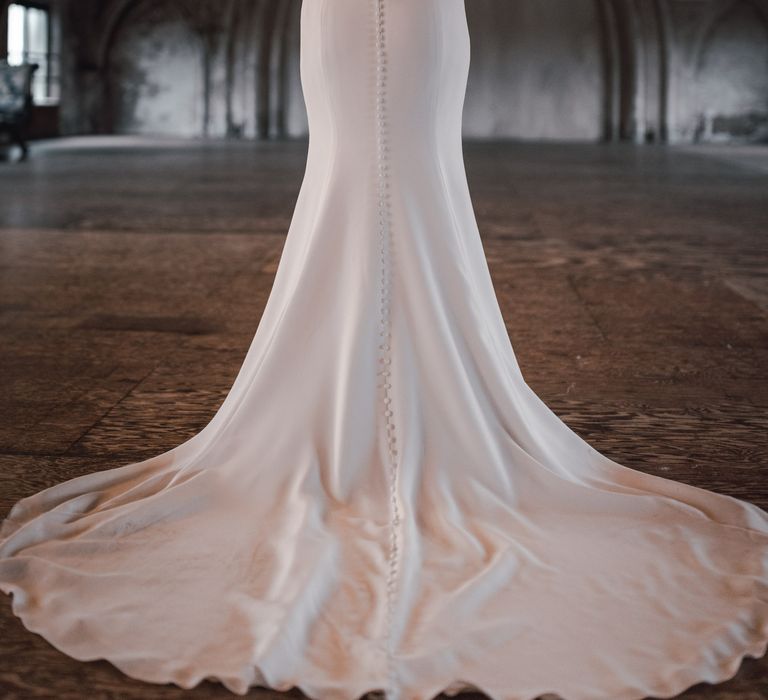 Floor-length bridal gown with veil blowing around the top of camera