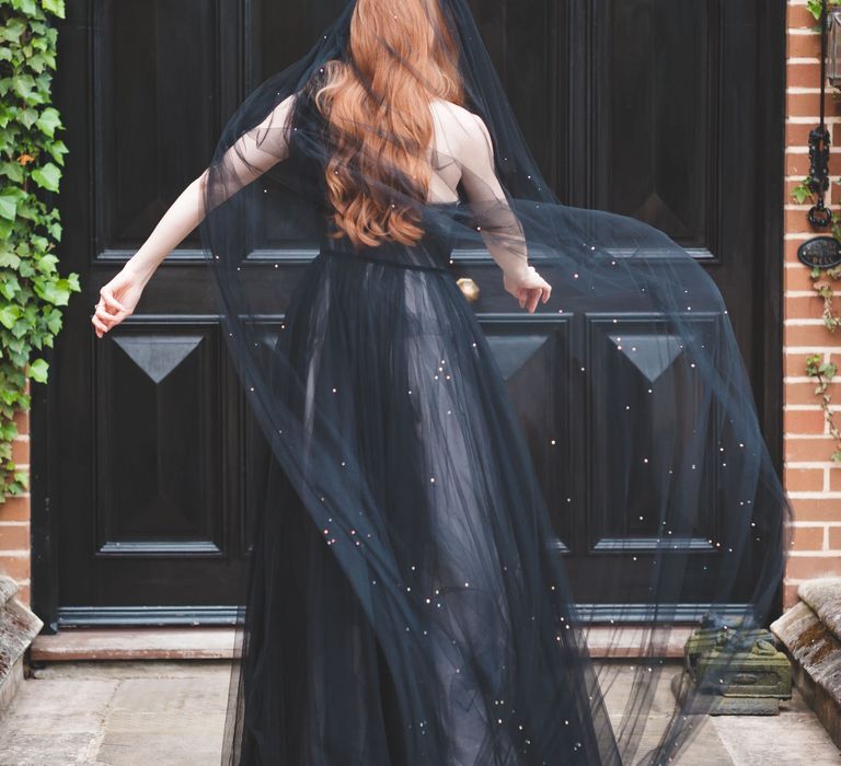 Bride in a one shoulder black tulle wedding dress with dramatic black veil at autism marriage wedding inspiration