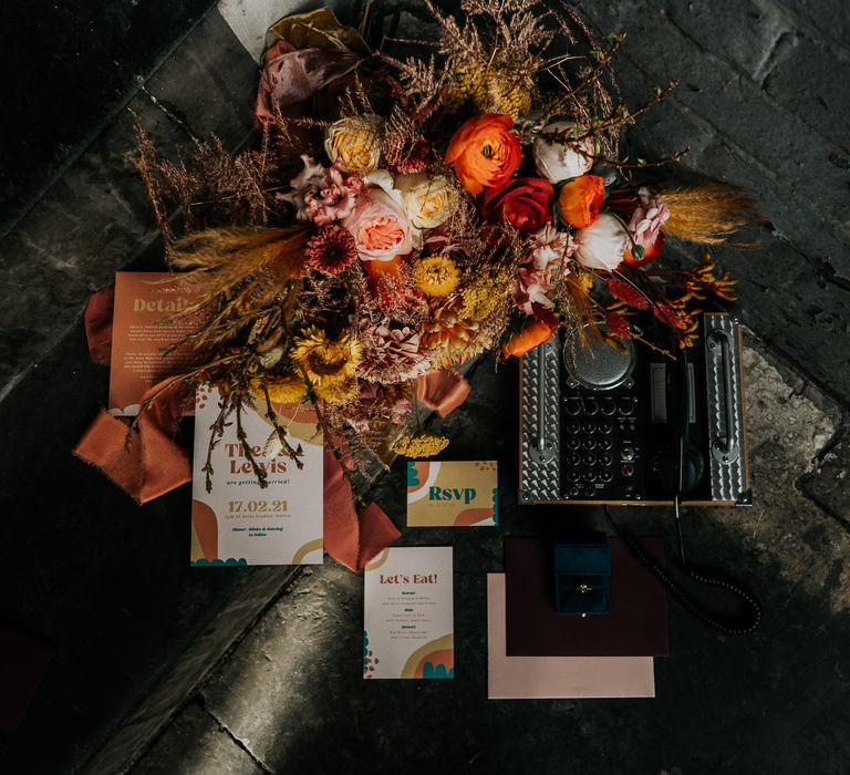 Vintage typewriter, orange and yellow wedding bouquet and retro 70s wedding stationery suite 