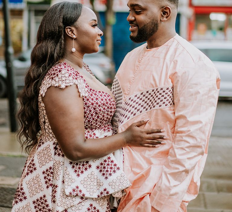 Bride & groom look lovingly at one another in their traditional Senegalese outfits  