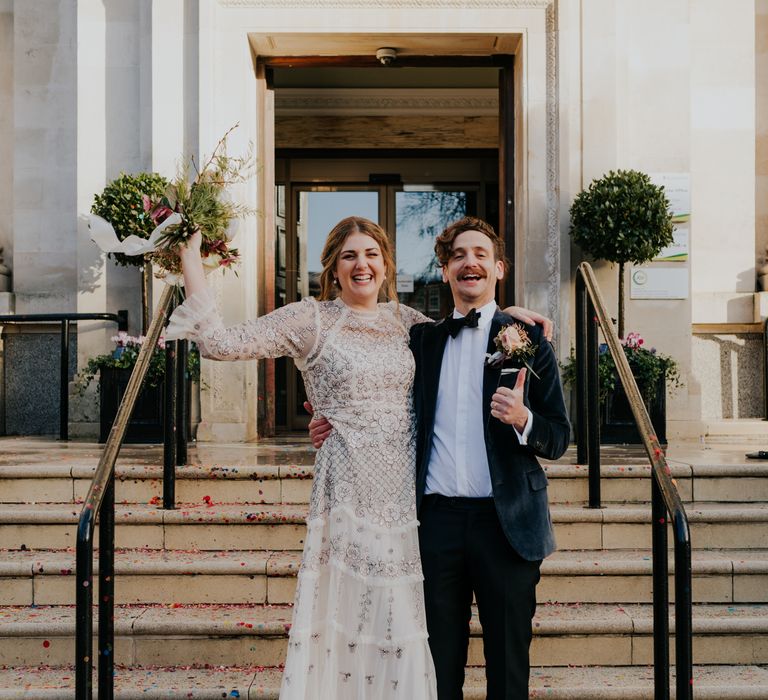 Bride & groom stand on Town Hall steps after wedding ceremony as they celebrate with one another