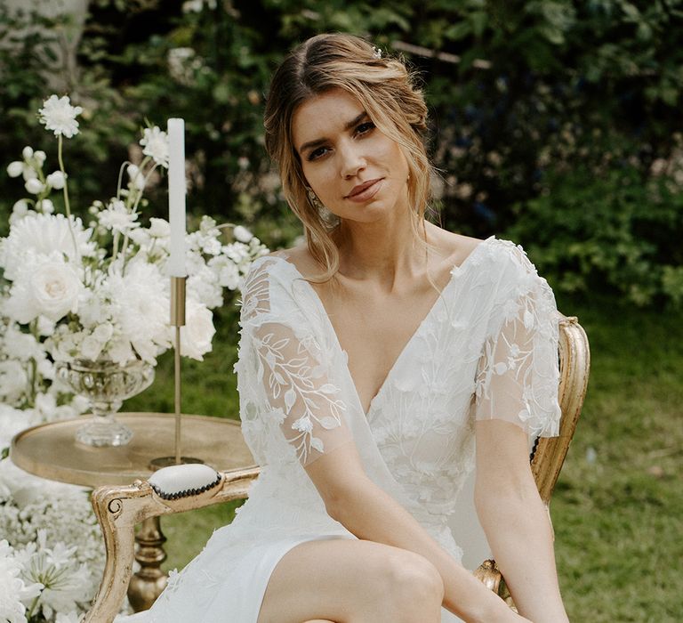 Beautiful bride with loosely pinned up hair in a lace wrap wedding dress and ankle strap Emmy London wedding shoes 