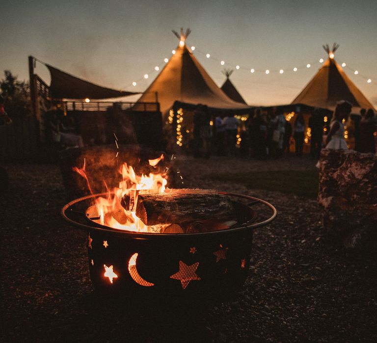 Tipi wedding venue lit up with fairy lights and fire pit at Inkersall Grange Farm