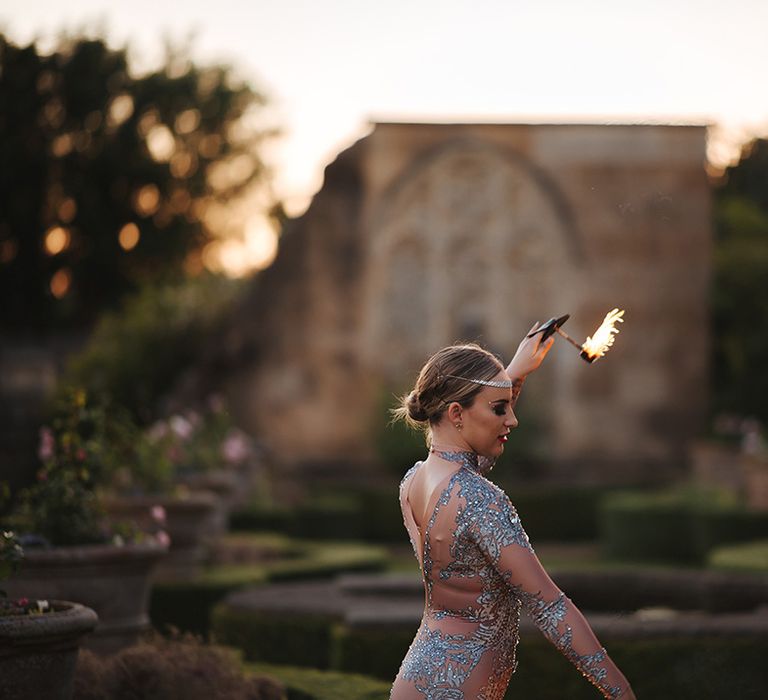 Fire dancer wears rhinestone bodysuit outdoors as she performs at Euridge Manor