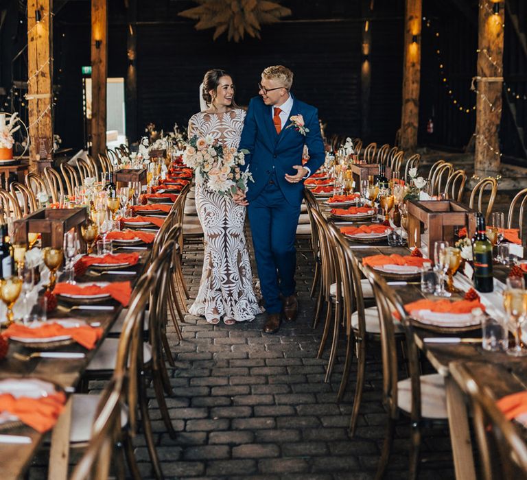 Boho Bride & Groom in Barn wedding surrounded by pampas installations, autumnal coloured dinner table settings & fairylights at Elmley Nature Reserve