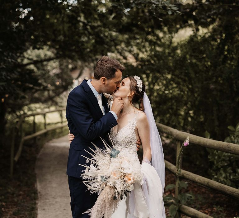 Bride & groom kiss outdoors on their wedding day