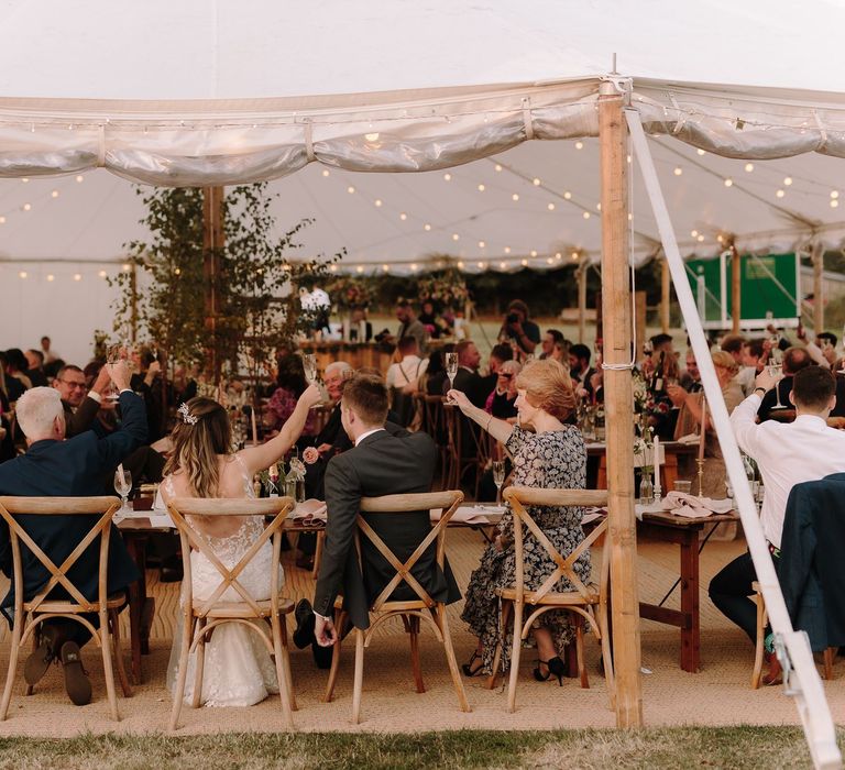 Bride and groom toast with guests at marquee wedding at White Pond Farm