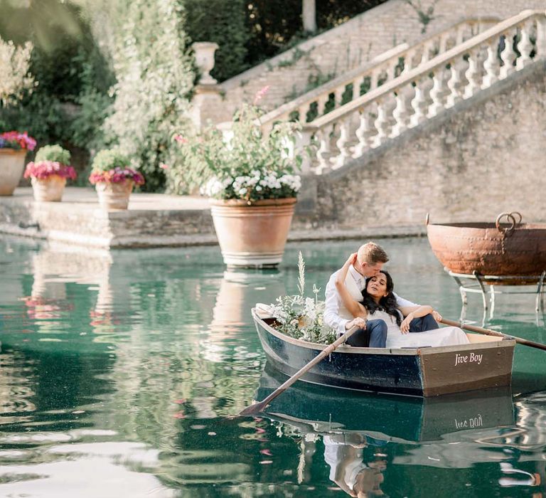 Bride & groom in canoe pictured on sparkling blue water 