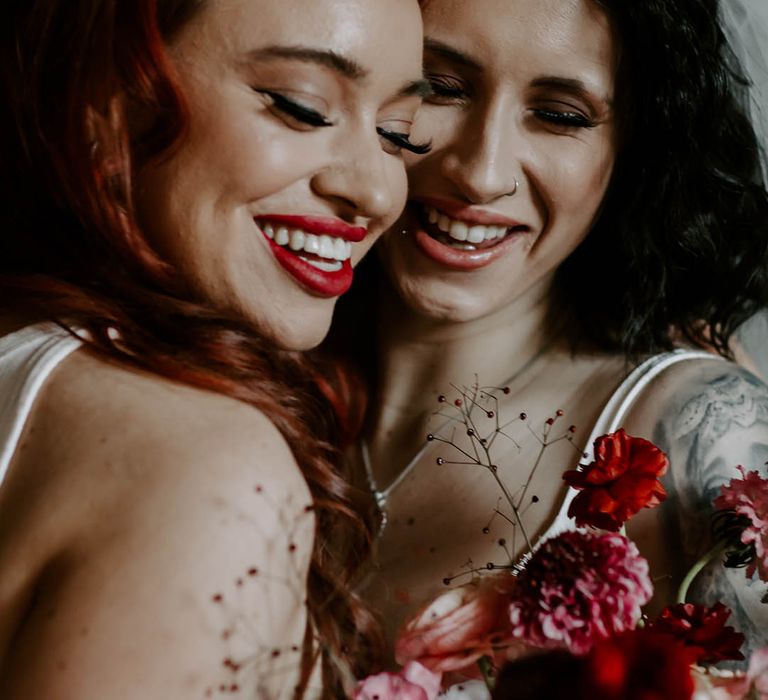 Intimate photo of an LGBTQI couple with winged eyeliner and bold red lipstick