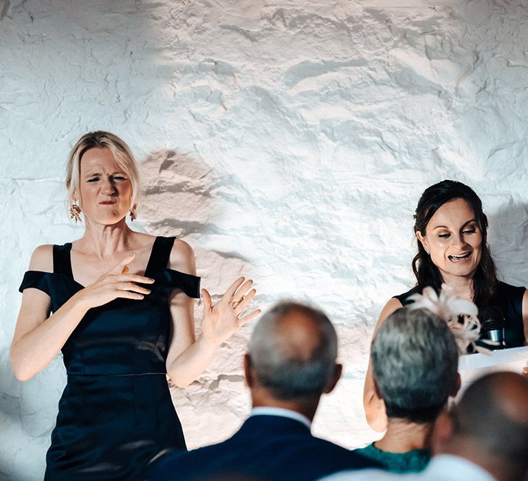 Wedding guest gives a speech with translator for sign language for deaf wedding attendants