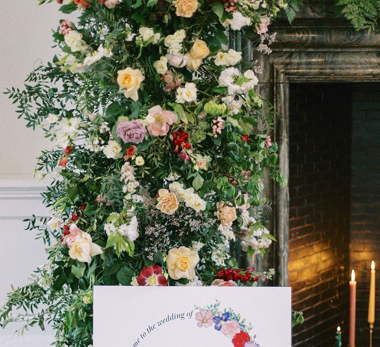 colourful column wedding flowers and welcome sign with floral motif 