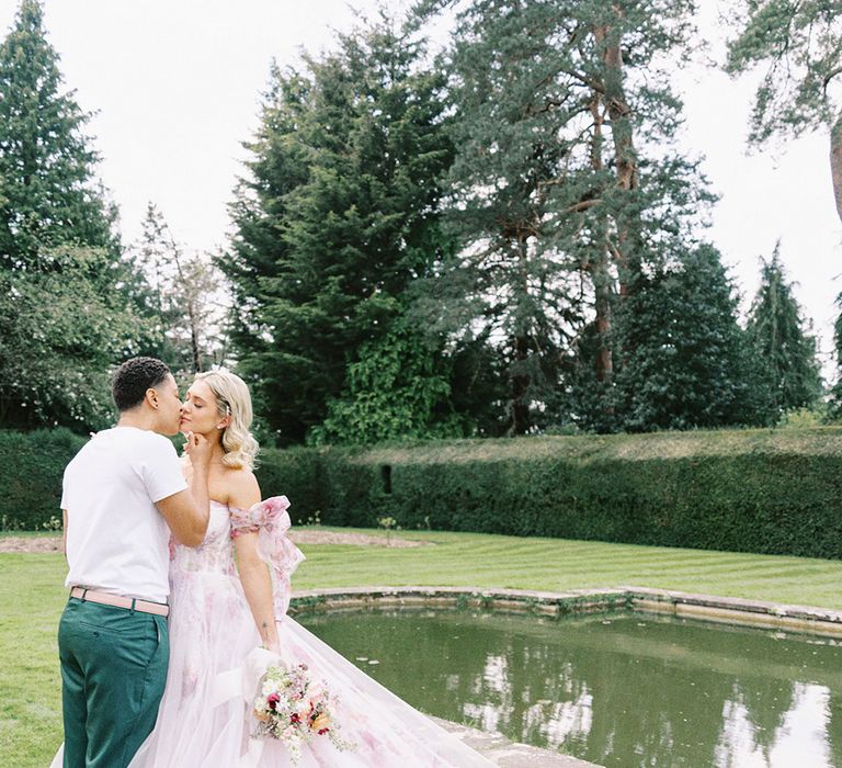 LGBTQI+ couple kissing in the gardens at Barnett Hill Hotel with a pink flower wedding dress