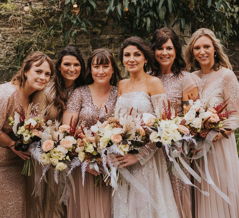 Bride in Zavana Couture with five bridesmaids in sparkly pink mismatched bridesmaid dresses