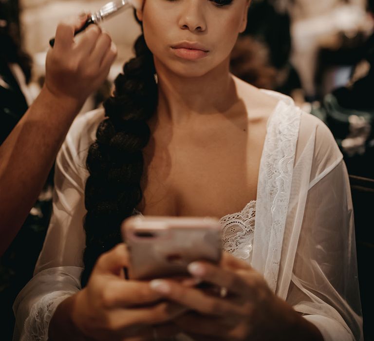 Bride wears her black hair braided complete with pearl hair accessories and statement eye shadow in gold and black 