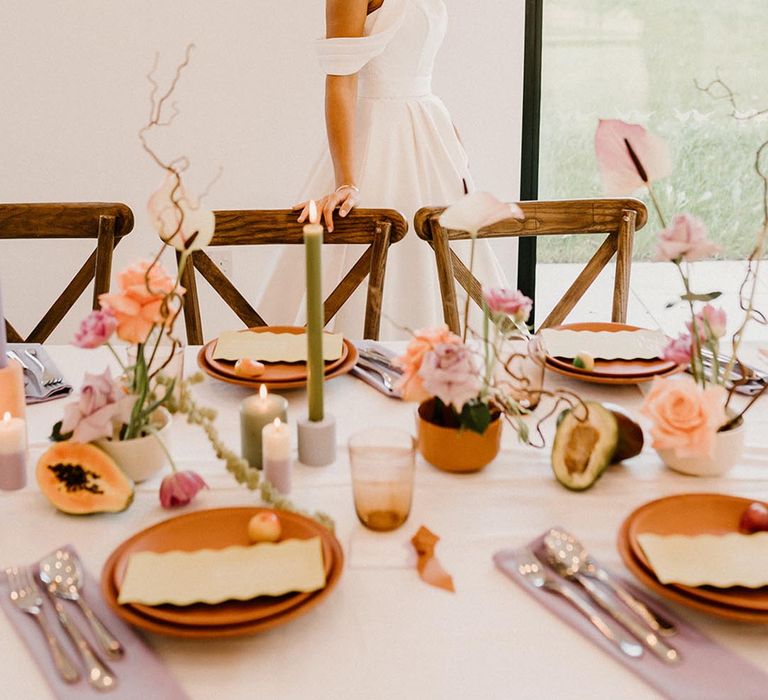 Pastel purple and green wedding table setting with terracotta plates and fruit decor 