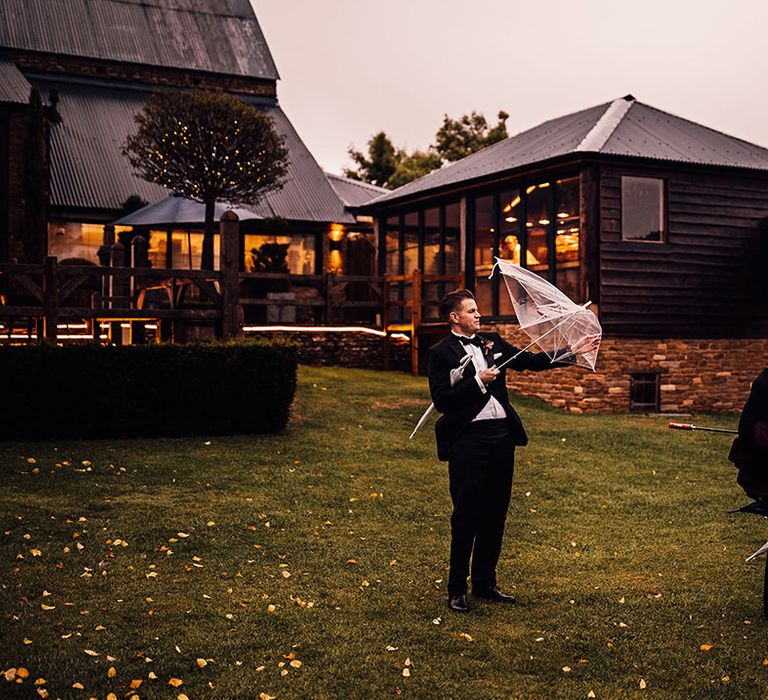 Wedding guests have struggles opening umbrellas on the windy and rainy day 