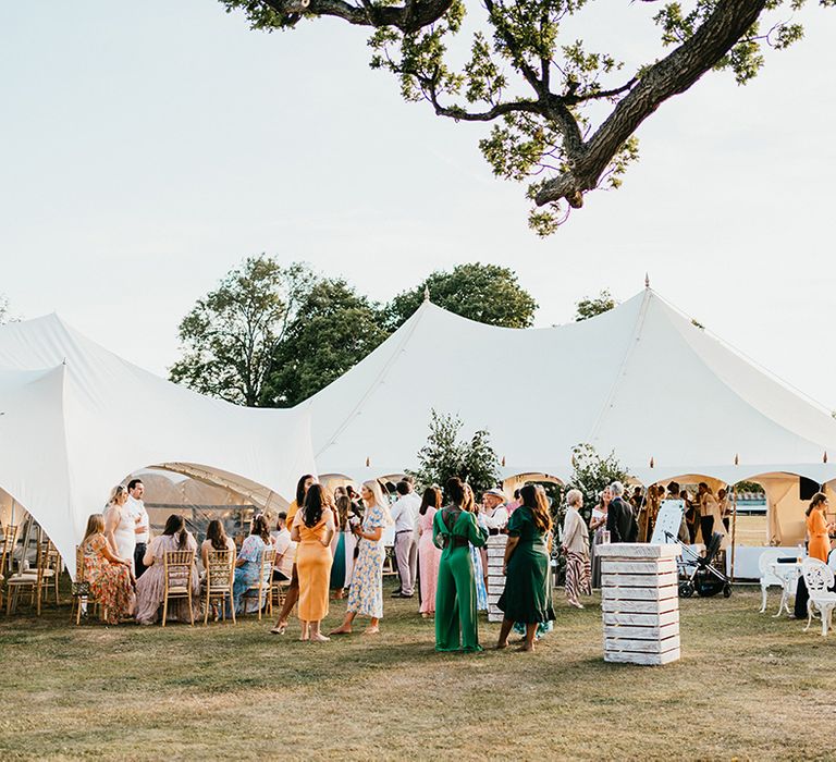 Wedding guests gather beside marquee during Sevenoaks back garden wedding 