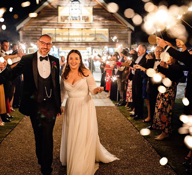 The bride and groom walk down the tunnel of sparklers being waved by the wedding guests for the sparkler send off 