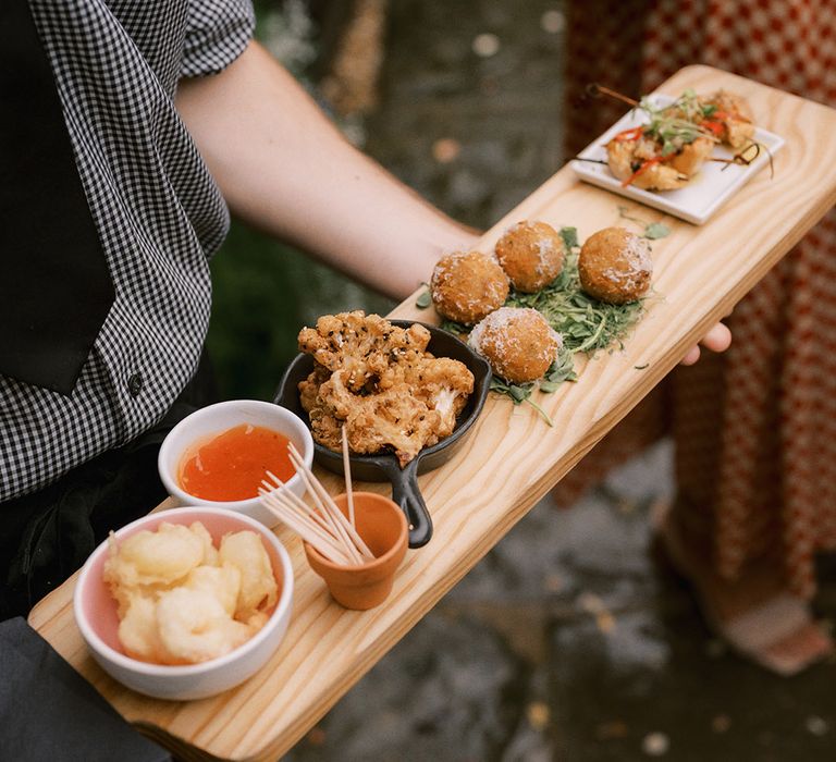 Wedding canapés with cauliflower, arancini balls, and prawns with chilli sauce and tooth picks 