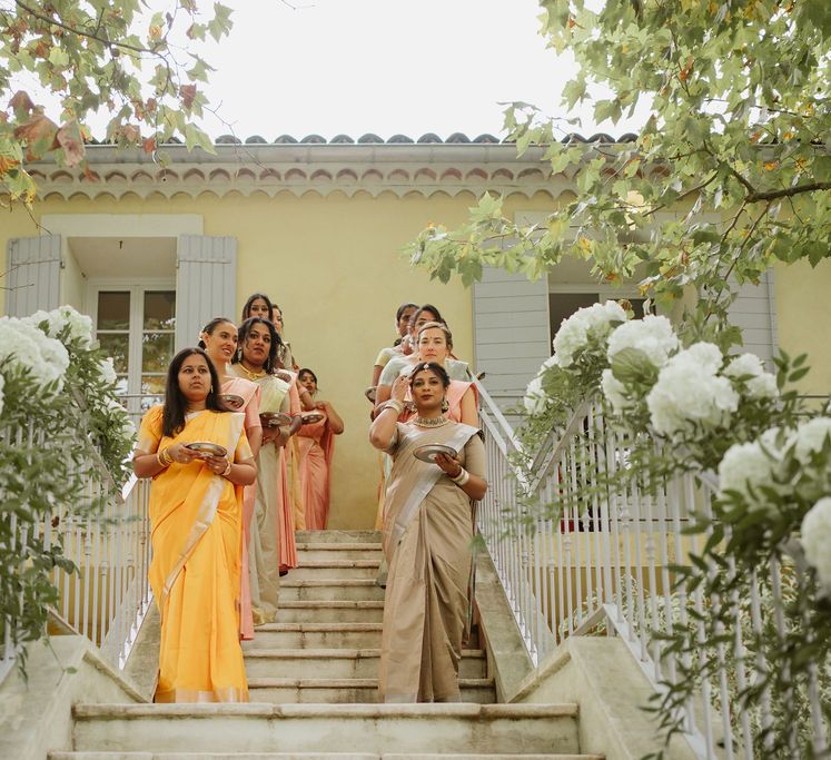 wedding party in different sari's holding baskets of petals at outdoor Provence wedding