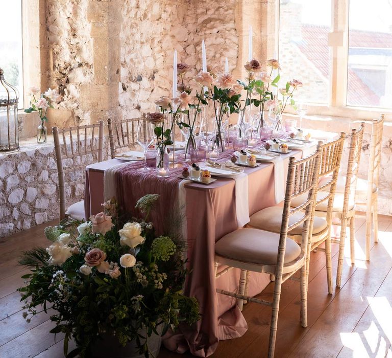 Contemporary wedding tablescape with lavender tablecloth, lilac tulle table runner, blush garden rose centrepieces, tea light candles and a trio of mini desserts 