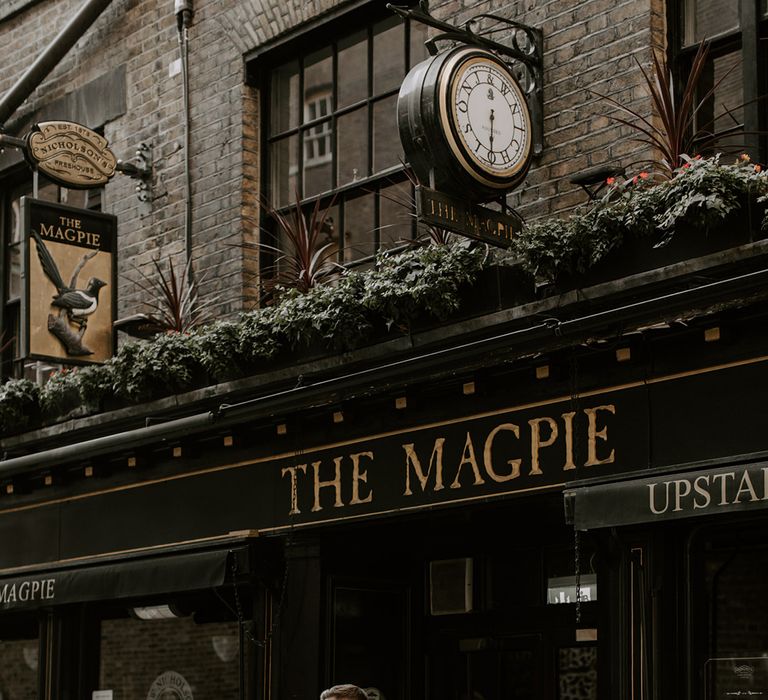 The bride and groom pop into a nearby pub for a few drinks together at their modern and minimal city wedding in London 