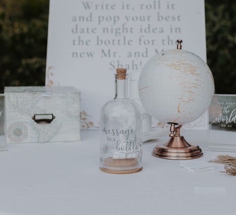 Alternative wedding guest book ideas - message in a bottle wedding guest book with large white wedding signage and globe decor