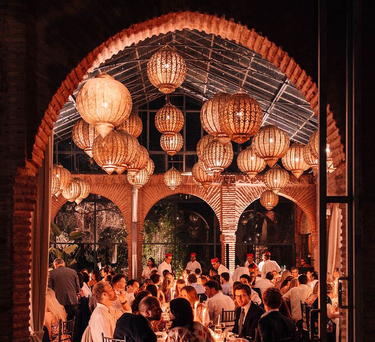 Beldi Country Club wedding venue with the guests seated for the wedding breakfast with golden lanterns 