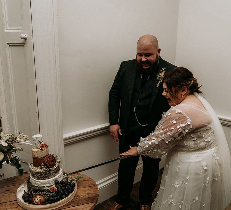 The bride and groom cut their cheese tower instead of wedding cake 