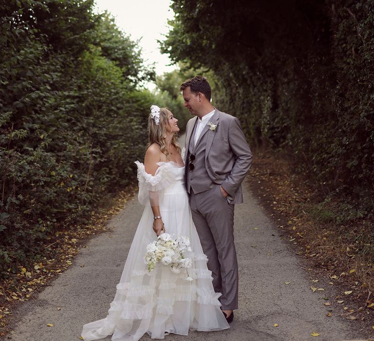 Groom in grey suit with the bride in Halfpenny London wedding dress 