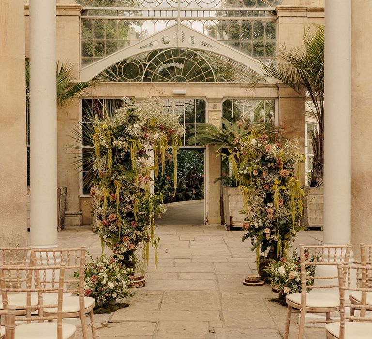 Syon Park glass house wedding venue with flower column altar decorations 