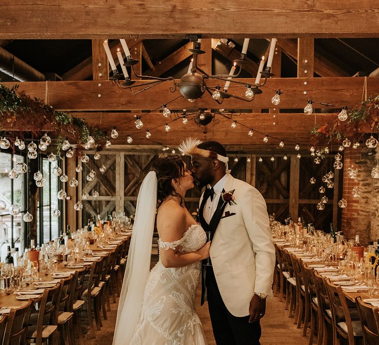 Groom in white tuxedo with the bride in a mermaid wedding dress at Dewsall Court country house 