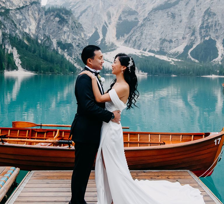 The Dolomites in Italy wedding with the bride and groom in a wooden row boat 