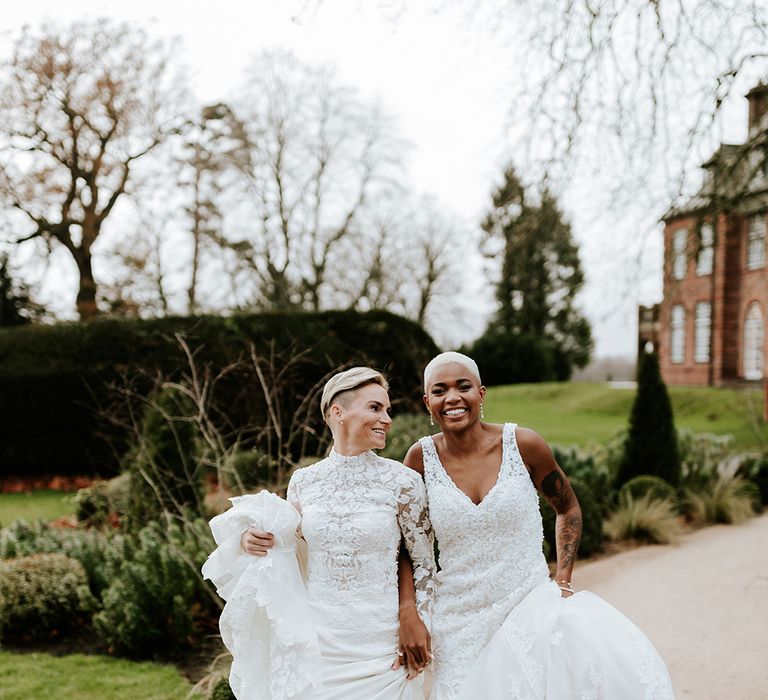 Two brides in delicate lace wedding dresses at their Welsh country house wedding 