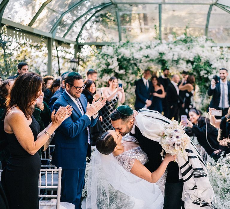 Bride and groom sharing a kiss as they walk back down the aisle as a married couple 