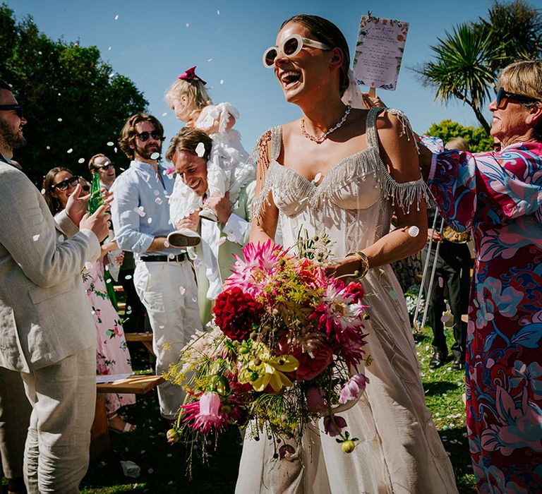 Bride in bejewelled sparkly wedding dress walking back down the aisle 