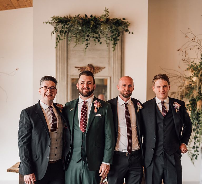 Groom and groomsmen in dark green wedding suits for contemporary wedding 