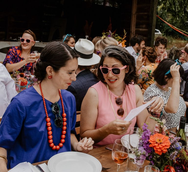 wedding guests at outdoor wedding reception with bunting and sunglasses