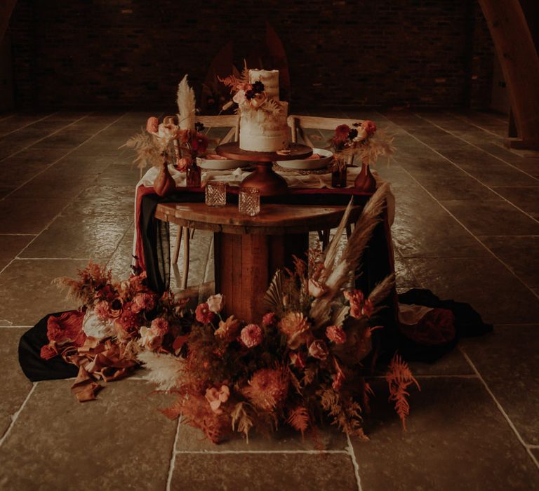 Cog wheel sweetheart table with wedding cake and flower decor 