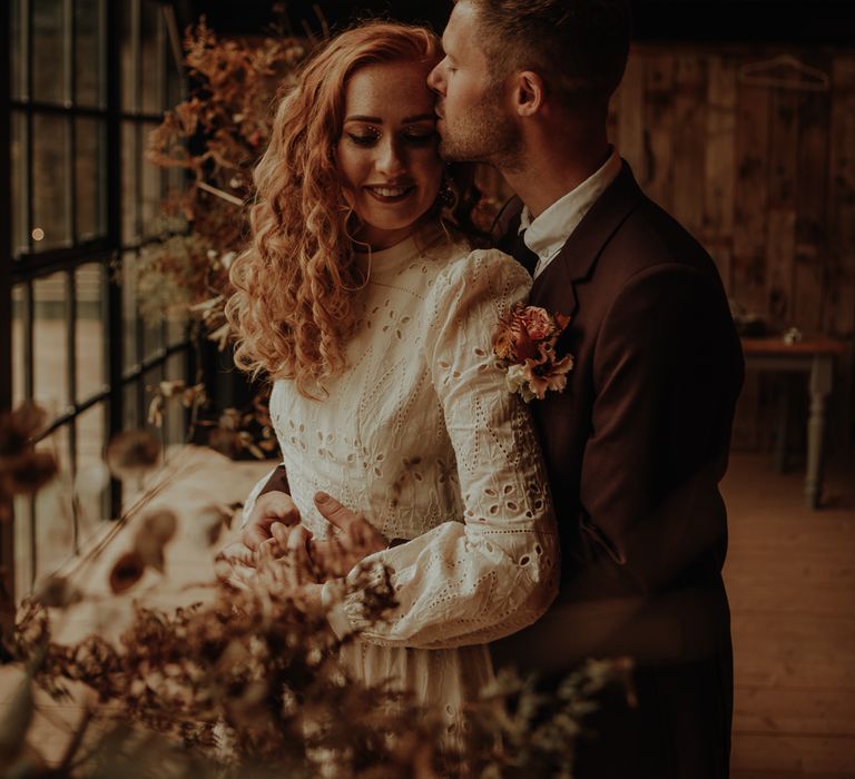 Bride and groom kissing at Hidden Cabin Barns in The Lake District 