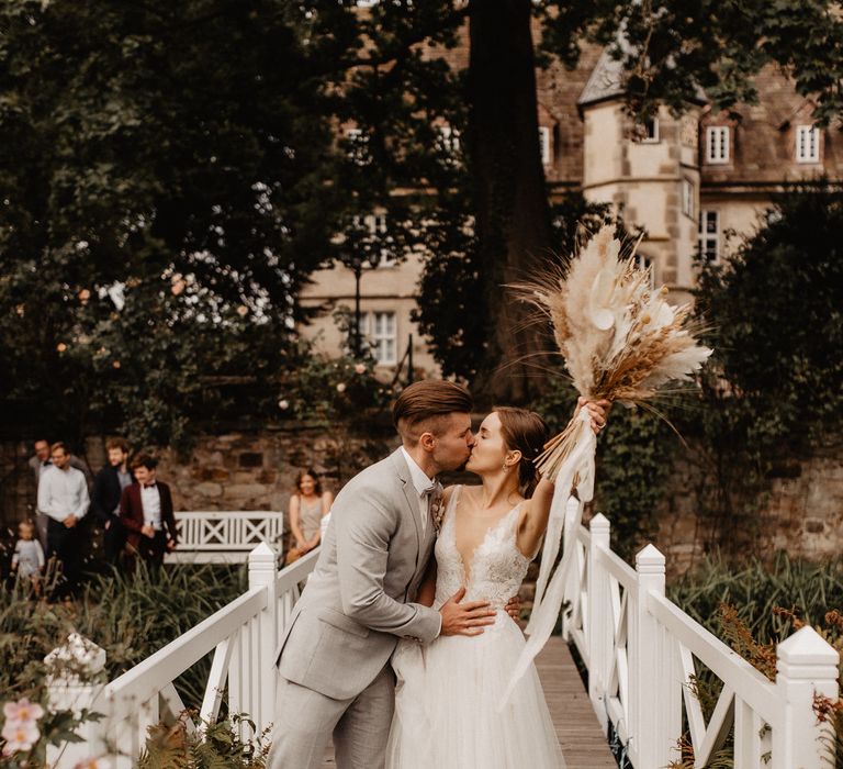 Bride and Groom just married on bridge with pampas grass bouquet 