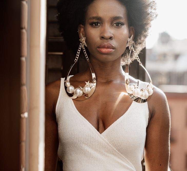 Bride in white strappy top with large golden earrings 