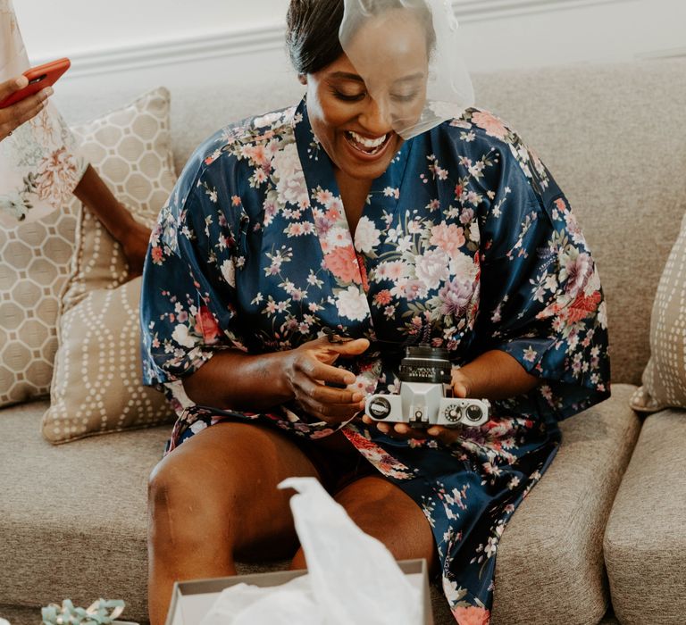 Black bride in blush veil and floral getting ready robe on the morning of the wedding 