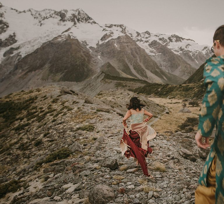 The couple running through the hills at New Zealand elopement