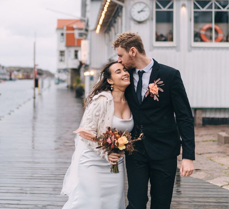 The bride and groom wandering the pier at their destination wedding in Sweden