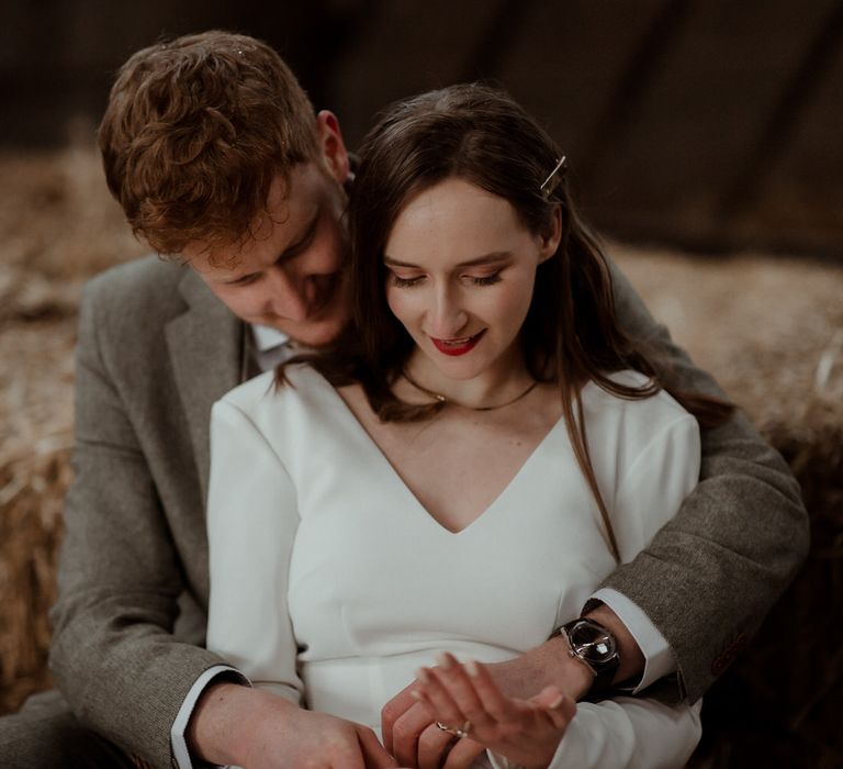 The bride and groom relaxing next to hay stacks